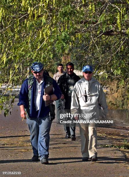 Monitoring, Verification and Inspection Commission experts conduct a search outside a facility for repairing machinery in west Baghdad 01 January...