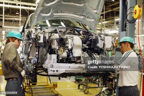 Workers of Japan's automaker Daihatsu Motor assemble parts into the company's two-seater sports car Copen at Daihatsu's Ikeda factory in Osaka, 13...
