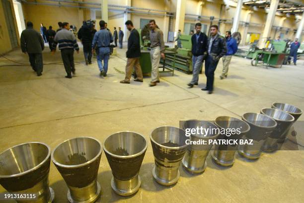 Iraqi officials and reporters walk past missile exhausts at the al-Amin missile parts factory in al-Amiriyah in the Falluja Province some 70 Kms west...