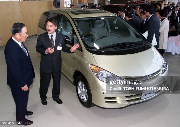 President of Toyota Motors Fujio Cho listens to Takashi Okuda , chief engineer of the company's new "Estima" in front of the new minivan during a...