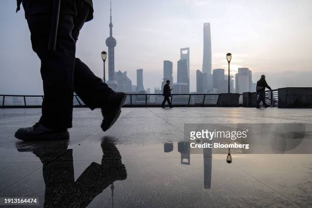 Pedestrians on the Bund in front of buildings in Pudong's Lujiazui Financial District in Shanghai, China, on Tuesday, Jan. 9, 2024. China's stock...
