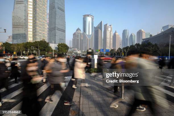 Pedestrians cross a road in Pudong's Lujiazui Financial District in Shanghai, China, on Tuesday, Jan. 9, 2024. China's stock market suffers from a...