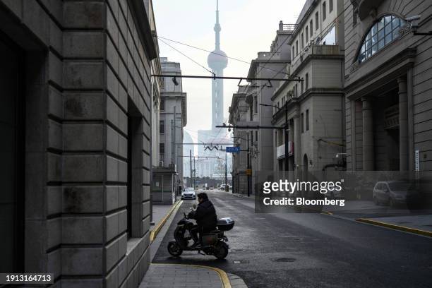 Motorist near the Bund in front of buildings in Pudong's Lujiazui Financial District in Shanghai, China, on Tuesday, Jan. 9, 2024. China's stock...