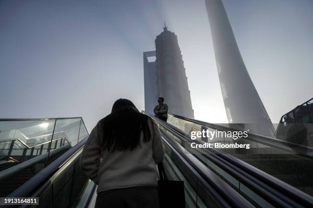 Pedestrians ride escalators in Pudong's Lujiazui Financial District in Shanghai, China, on Tuesday, Jan. 9, 2024. China's stock market suffers from a...