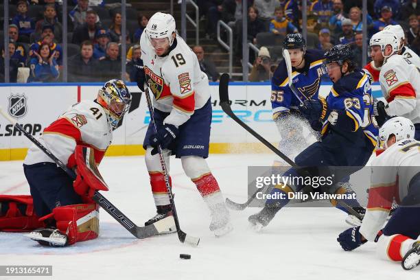 Anthony Stolarz and Matthew Tkachuk both of the Florida Panthers defend against Jake Neighbours of the St. Louis Blues in the first period at...