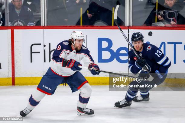Ivan Provorov of the Columbus Blue Jackets and Gabriel Vilardi of the Winnipeg Jets eye the flying puck during first period action at the Canada Life...