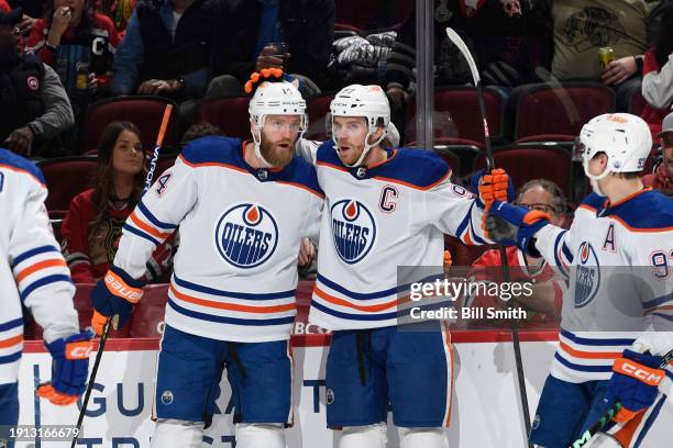 Connor McDavid of the Edmonton Oilers celebrates with teammate Mattias Ekholm after scoring against the Chicago Blackhawks in the second period at...