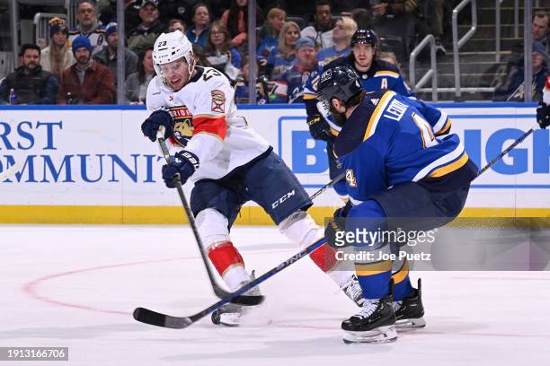 Carter Verhaeghe of the Florida Panthers and Nick Leddy of the St. Louis Blues battle for the puck on January 9, 2024 at the Enterprise Center in St....