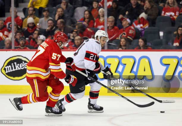 Nick DeSimone of the Calgary Flames and Mathieu Joseph of the Ottawa Senators battle for the puck during the second period at the Scotiabank...
