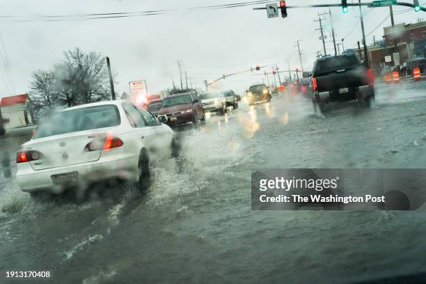 Langley Park, Maryland Cars make their way through flooding at the intersection of University Blvd. And New Hampshire Ave. In Langley Park, MD. On...