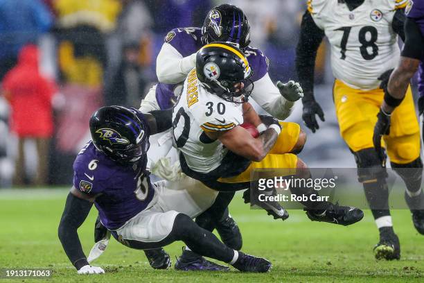 Jaylen Warren of the Pittsburgh Steelers is tackled by Patrick Queen of the Baltimore Ravens and Justin Madubuike in the second quarter of a game at...
