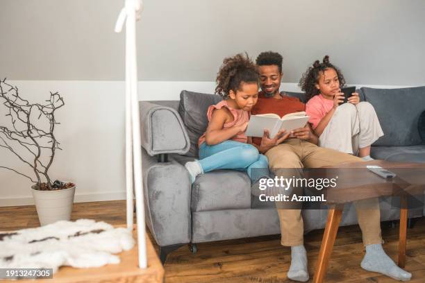 diverse family reading books and e-books at home - family and happiness and diverse imagens e fotografias de stock