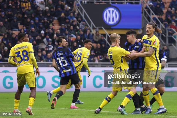 Alessandro Bastoni of FC Internazionale clashes with Josh Doig and Milan Djuric of Hellas Verona during the Serie A TIM match between FC...