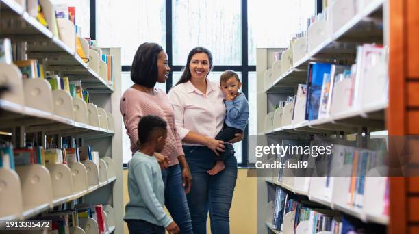 multiracial mothers and sons in library - image library stock pictures, royalty-free photos & images
