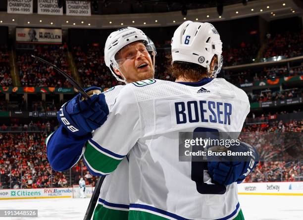 Elias Pettersson of the Vancouver Canucks celebrates his goal at 2:35 of the third period against the New Jersey Devils and is joined by Brock Boeser...