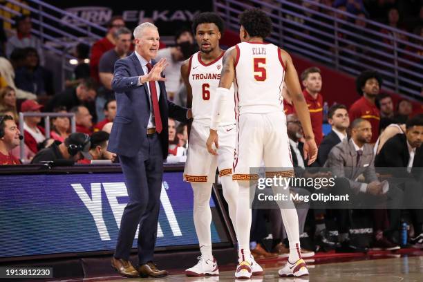 Head coach Andy Enfield of the USC Trojans speaks with Bronny James and Boogie Ellis during the second half against the Stanford Cardinal at Galen...
