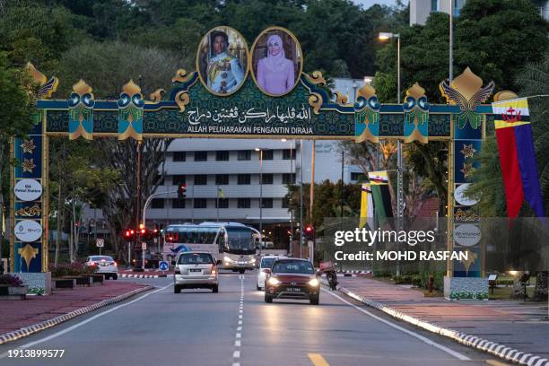 Motorists drive under the portraits of groom Prince Abdul Mateen and bride Anisha Rosnah -- with a slogan in Bahasa Melayu that reads "God protect...