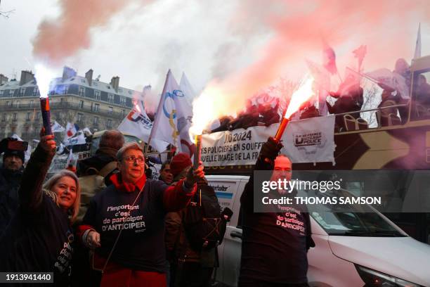 Protesters hold flares as they take part in a demonstration called by French police union 'Unite SGP police-FO' to protest against a lack of...