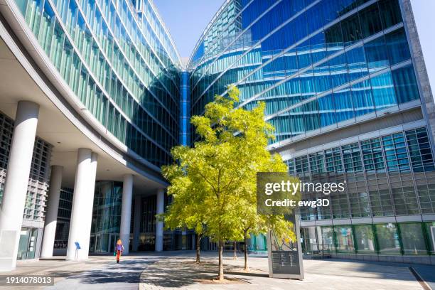 blue glass modern office buildings with green trees in milan, italy - milan business stock pictures, royalty-free photos & images