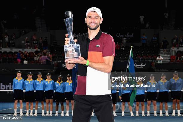 Grigor Dimitrov of Bulgaria poses with the trophy after winning his final match against Holger Rune of Denmark during day eight of the 2024 Brisbane...