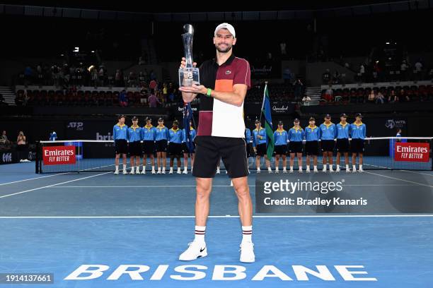 Grigor Dimitrov of Bulgaria poses with the trophy after winning his final match against Holger Rune of Denmark during day eight of the 2024 Brisbane...