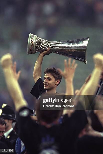 Olaf Thon of Schalke 04 lifts the UEFA Cup after the second leg of the final at the San Siro in Milan, Italy. The match was level after the two legs,...