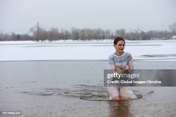 Woman comes from cold water of Dnipro river after plunging during Epiphany celebrations on January 6, 2024 in Kyiv, Ukraine. Ukraine celebrates...