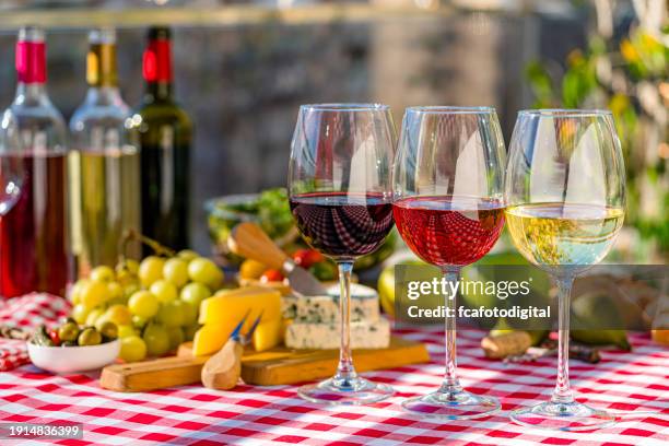 vino rosato, vino rosso e bicchieri da vino bianco e specialità gastronomiche sul tavolo della terrazza - pinot grigio wine foto e immagini stock