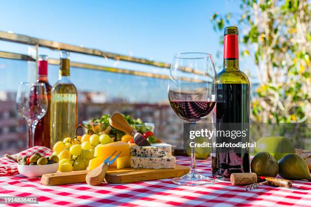 bottiglia e bicchiere di vino rosso e specialità gastronomiche sul tavolo della terrazza - pinot grigio wine foto e immagini stock