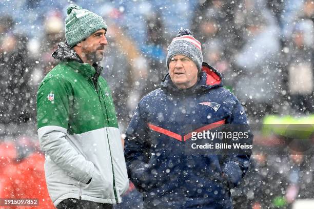 Aaron Rodgers of the New York Jets and New England Patriots head coach Bill Belichick speak before a game at Gillette Stadium on January 07, 2024 in...