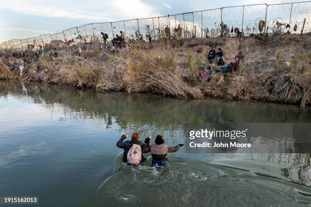 In an aerial view, immigrants wade across the Rio Grande while crossing from Mexico into the United States on January 07, 2024 in Eagle Pass, Texas....