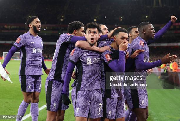 Luis Diaz and Trent Alexander-Arnold of Liverpool celebrate with teammates their team's first goal, an own goal scored by Jakub Kiwior of Arsenal...