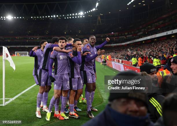 Luis Diaz and Trent Alexander-Arnold of Liverpool celebrate with teammates their team's first goal, an own goal scored by Jakub Kiwior of Arsenal...