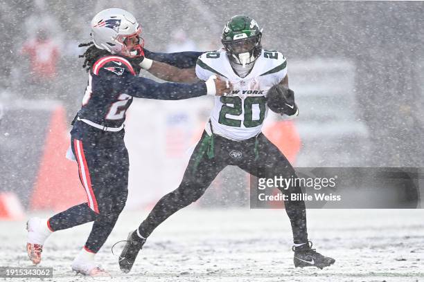 Breece Hall of the New York Jets stiff arms Kyle Dugger of the New England Patriots in the first half at Gillette Stadium on January 07, 2024 in...