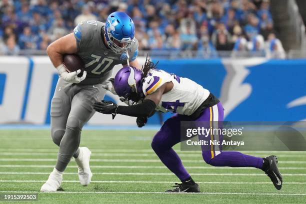 Dan Skipper of the Detroit Lions is tackled by Nick Muse of the Minnesota Vikings xd3 at Ford Field on January 07, 2024 in Detroit, Michigan.