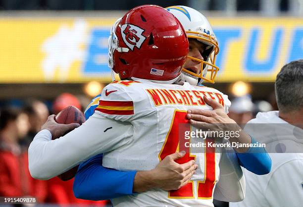 Scott of the Los Angeles Chargers and James Winchester of the Kansas City Chiefs hug before a game at SoFi Stadium on January 07, 2024 in Inglewood,...
