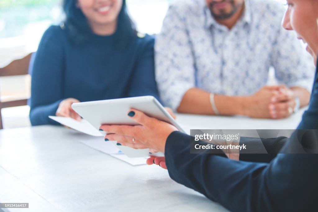 Mature couple meeting with financial advisor or real estate agent at home