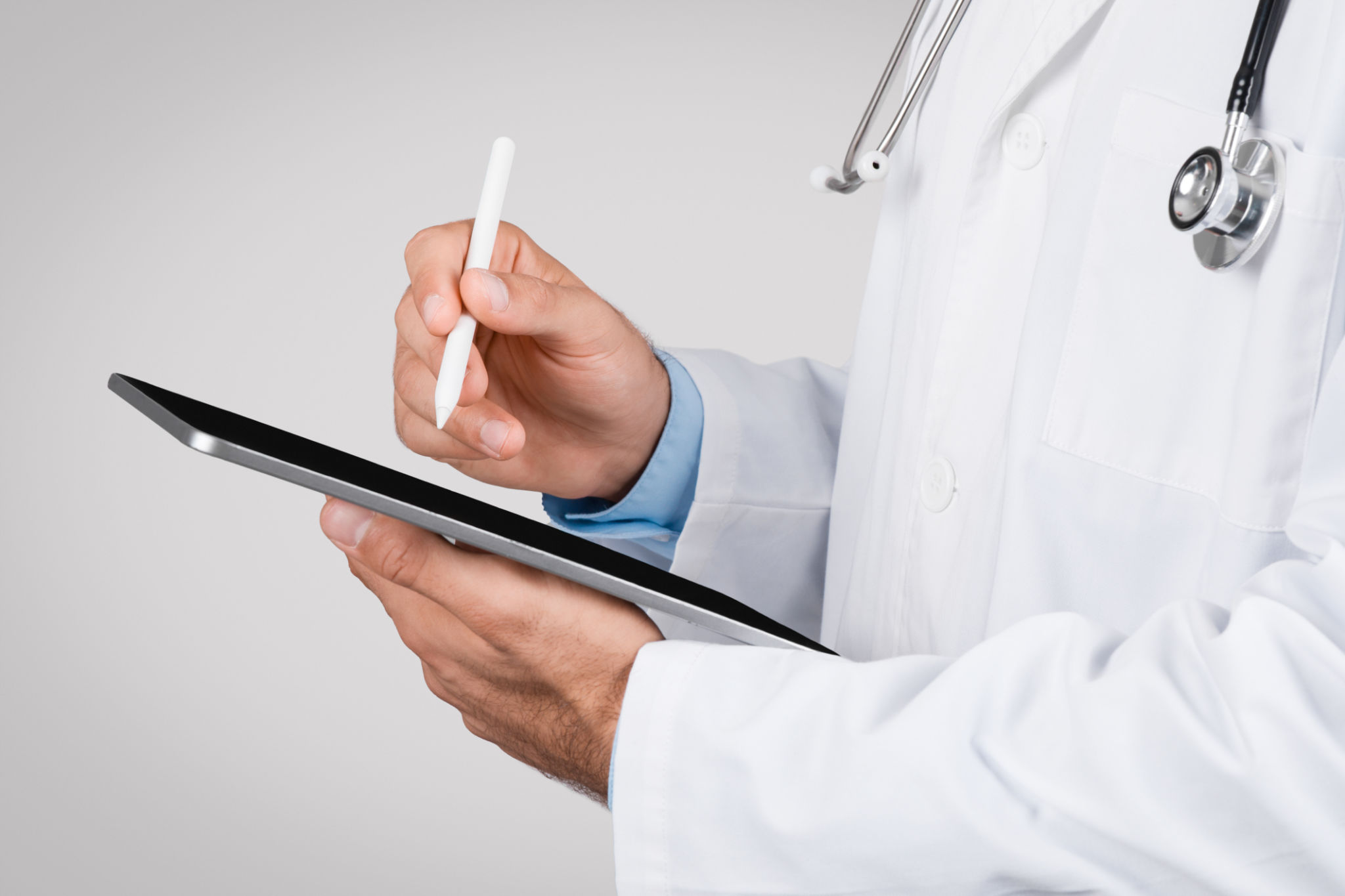 Doctor using a digital tablet with stylus pen, closeup Doctor using a digital tablet with stylus pen, closeup