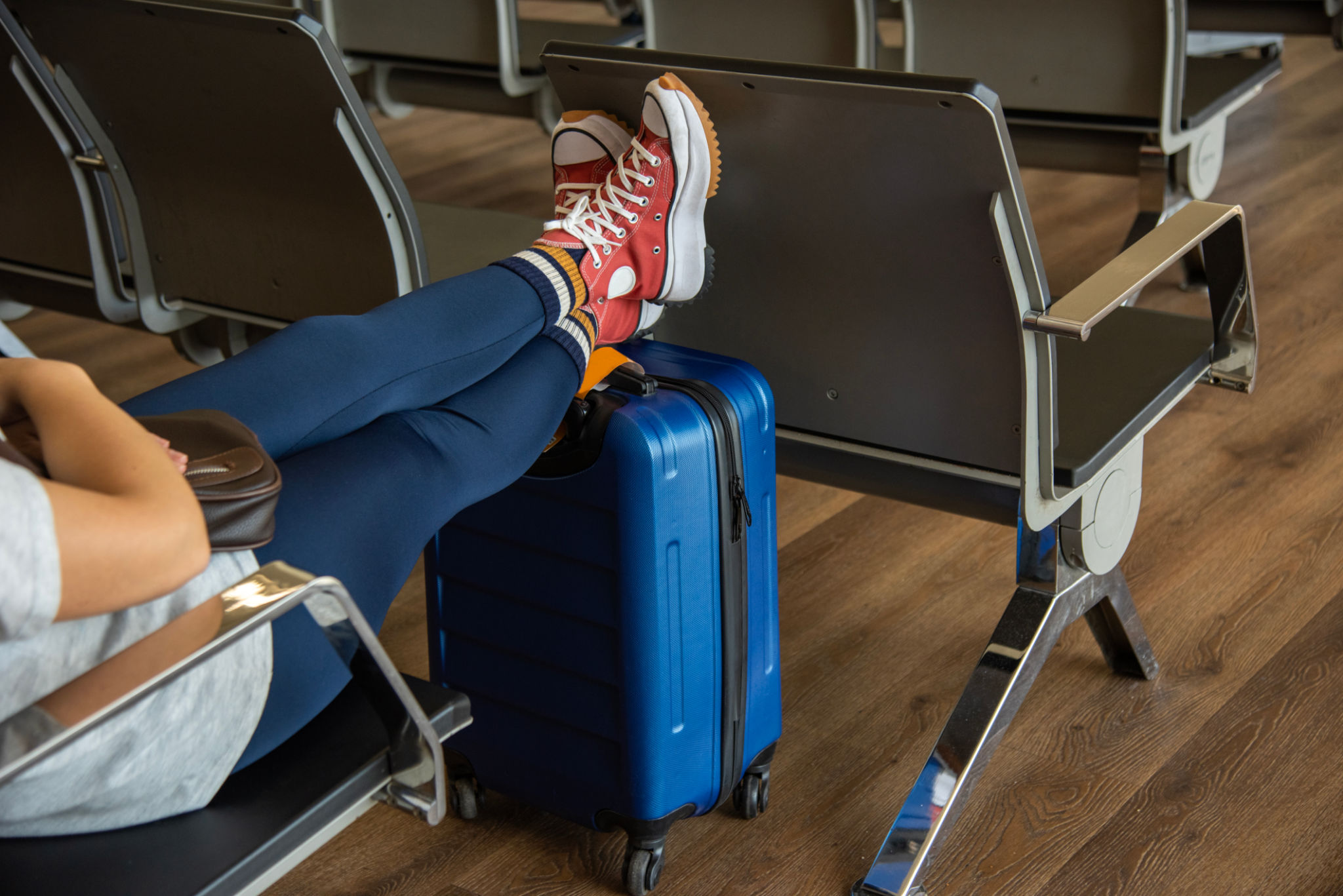 Bored and tired beautiful young woman is waiting her flight in international airport sitting in hall Bored and tired beautiful young woman is waiting her flight in international airport sitting in hall