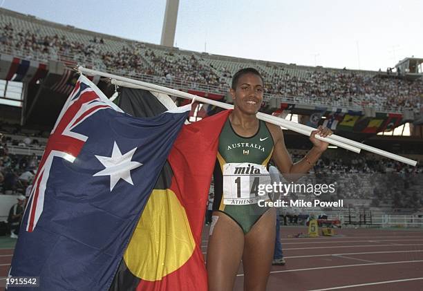 Cathy Freeman of Australia carries the national and Aboriginal flags after winning the gold medal in the 400 metres final during the World...