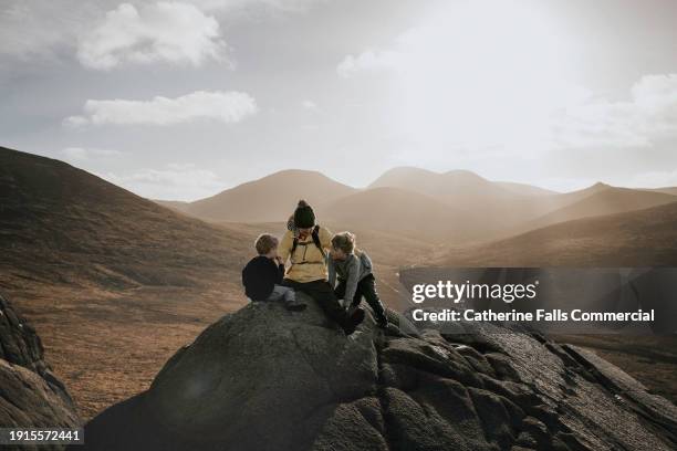 a fit and healthy grandmother climbs a mountain with her grandsons - extreme sports kids stock pictures, royalty-free photos & images