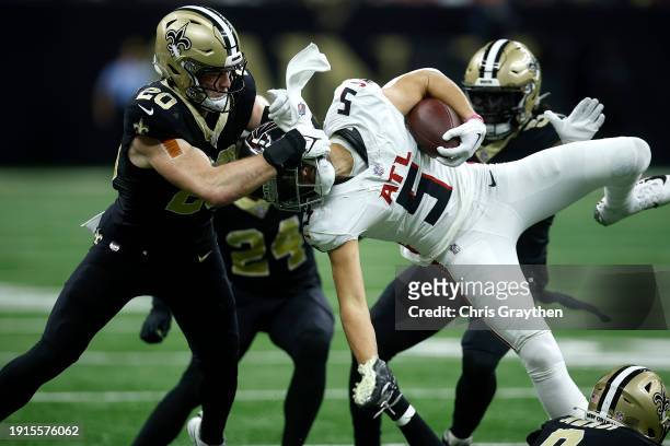 Pete Werner of the New Orleans Saints tackles Drake London of the Atlanta Falcons in the third quarter during a game at Caesars Superdome on January...