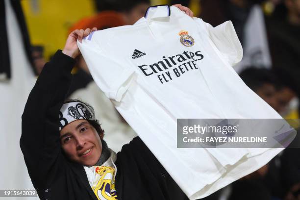 Real Madrid supporter waves the team's jersey ahead of the Spanish Super Cup semi-final football match between Real Madrid and Atletico Madrid at the...