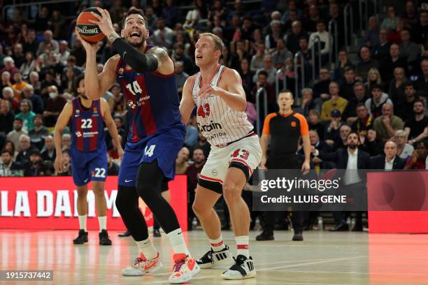 Barcelona's Spanish center Willy Hernangomez is challenged by Olympiacos Piraeus' American forward Luke Sikma during the Euroleague round 20...