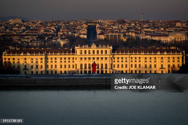 Woman enjoys a golden hour view from the Gloriette hill above the Schoenbrunn palace, the main summer residence of the Habsburg rulers, in Vienna,...