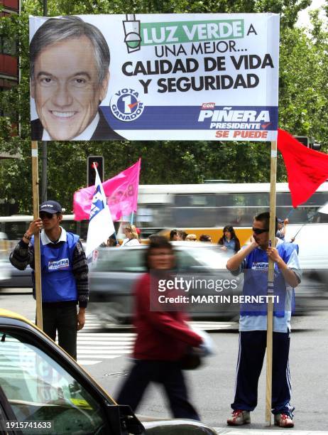 Peatones cruzan próximo a un cartel electoral del candidato a la Presidencia de Chile, Sebastian Piñera, del partido Renovación Nacional, en...