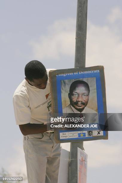Supporter of one of the seven candidates for next weeks Namibia presidential election puts up posters 10 November 2004 in Uskes, 200km west of the...