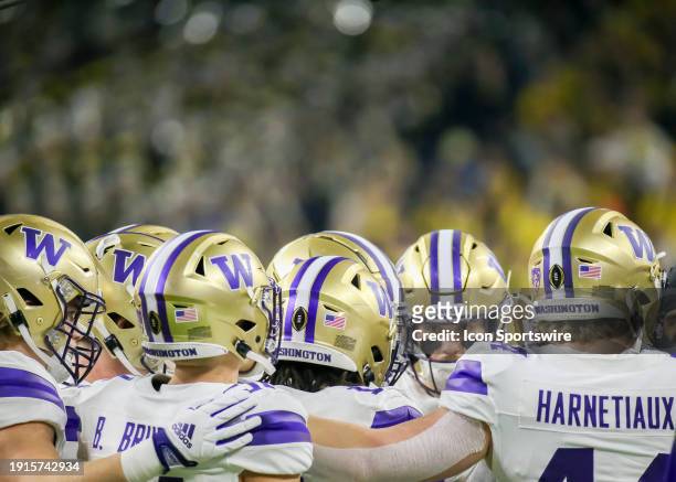 Washington Huskies join in a huddle during the CFP National Championship game between the Michigan Wolverines and Washington Huskies on January 8,...