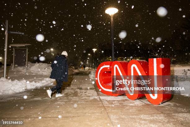 The CNN logo is seen as snow falls outside the fifth Republican presidential primary debate at Drake University in Des Moines, Iowa, on January 10,...