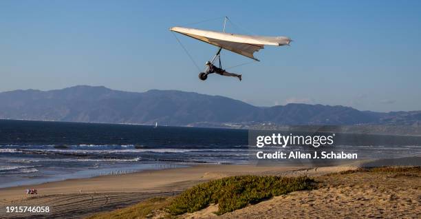 El Segundo, CA Hang gliders Erika Klein, of Pasadena, soars high over the beach as she takes advantage of strong, gusty winds at the Dockweiler Beach...